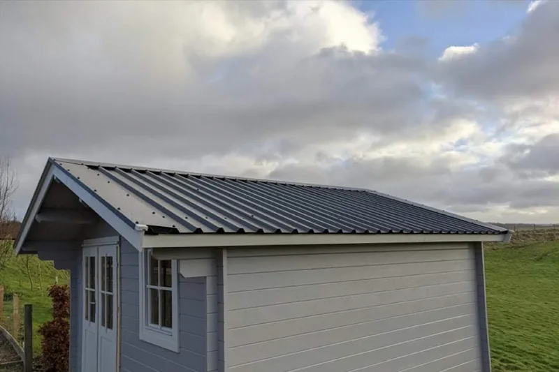 Metal standing-seam roof on completed timber cabin